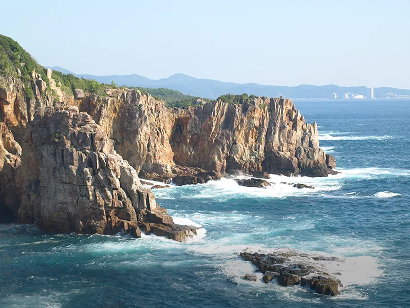 険しい岩肌が続く海岸線。青い海と空が広がる雄大な景色。