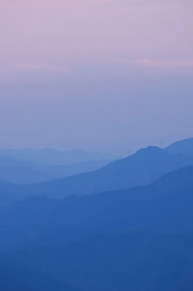 朝もやに包まれた青い山脈。奥行きを感じさせる、雄大な景色。