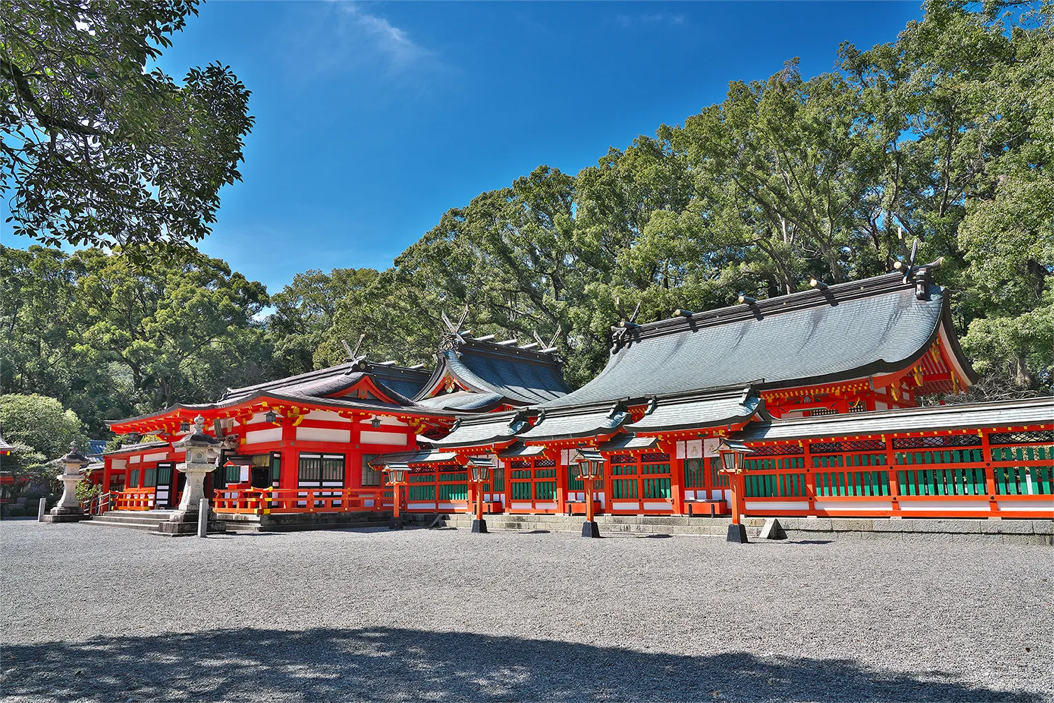 朱塗りの社殿が美しい神社。青空と緑に映える鮮やかな色彩。